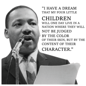 Man speaking into a microphone, holding paper.